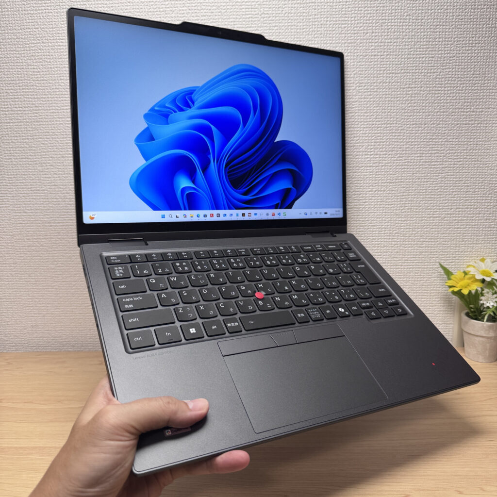 Holding the laptop with one hand